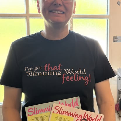 Ruth wearing a Slimming World t-shirt holding the magazines